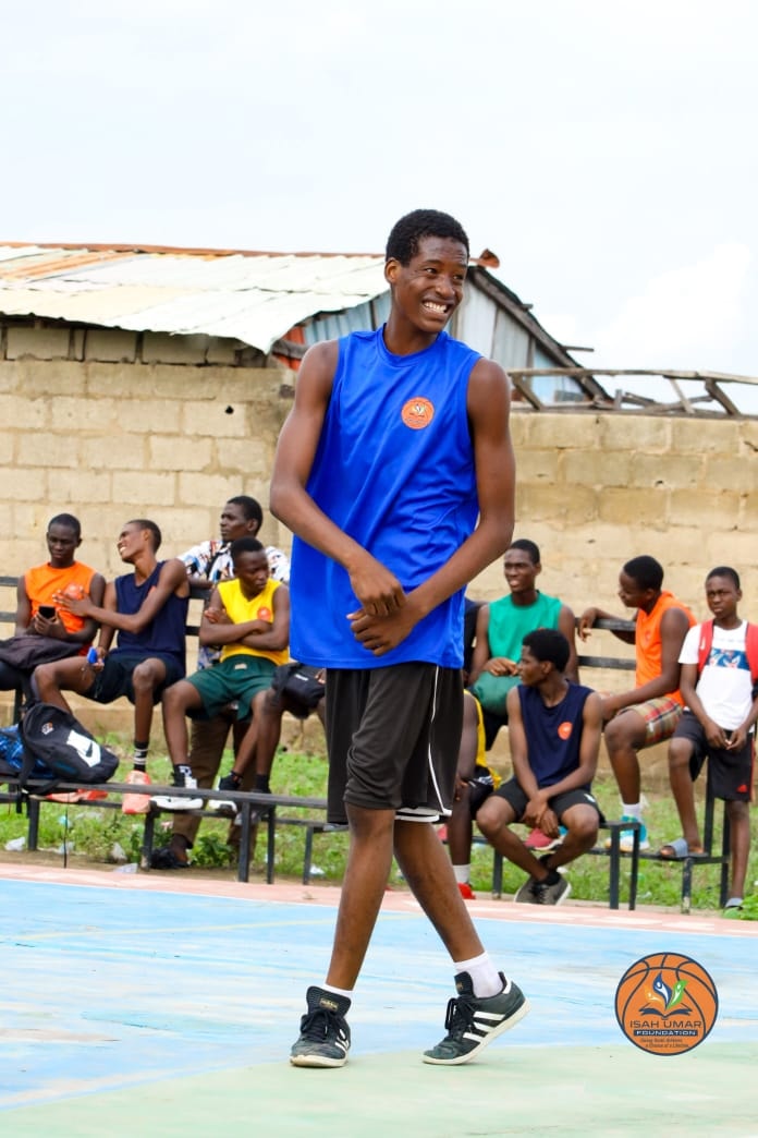 Young male player in blue IUF jersey smiling on the court at the 3X3 Championship